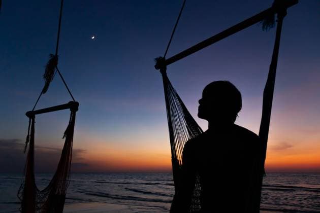 Creative Highlights Symbolbilder Anonymous person silhouette stands next to a hammock on the beach, with the last light of sunset and a crescent moon above Model Released EduardoGavira_ID19719_584789_003 Copyright: xEduardoxGavirax RECORD DATE NOT STATED