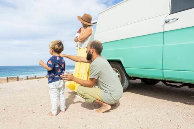 A young family enjoys a serene moment by the sea beside their retro van, embracing the joys of simple travel and togetherness. Model Released JuanAizpuru_ID19709_584473_016 Copyright: xJuanxAizpurux