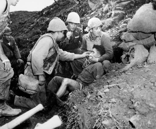 KOREAN WAR: ARMY CHAPLAIN. A U.S. Army chaplain giving extreme unction as American hospital corpsmen tend to a soldier critically wounded when a mortar shell scored a direct hit on his bunker atop Hill 266, known as Old Baldy, during the Korean War, 1952.  Copyright: xGRANGERx xGRANGERx 0001537