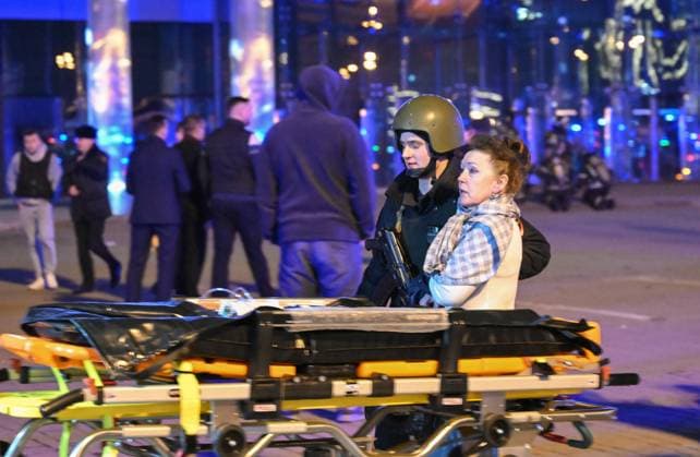 Russia Concert Shooting 8647717 22.03.2024 A law enforcement officer escorts a woman near the Crocus City Hall concert venue following a reported shooting incident, near Moscow, Russia. Several gunmen in combat fatigues burst into a concert hall on March 22 and fired automatic weapons at the crowd, injuring an unspecified number of people. Maksim Blinov Sputnik Moscow region Russia  Copyright: xMaksimxBlinovx