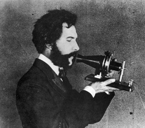 ALEXANDER GRAHAM BELL (1847-1922). American (Scottish-born) teacher and inventor. An actor portrays Bell speaking into his Centennial telephone at the Philadelphia Centennial International Exhibition in June 1876, in a filmed reenactment of 1926.  Copyright: xGRANGERx xGRANGERx 0065208