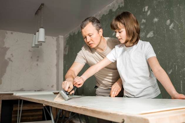 Father and daughter applying glue together on wallpaper at home model released, Symbolfoto property released, ELMF00093