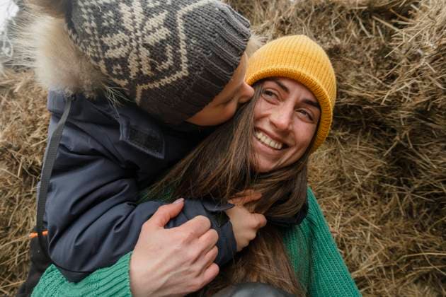 Playful boy embracing mother by haystack at farm model released, Symbolfoto, KVBF00039