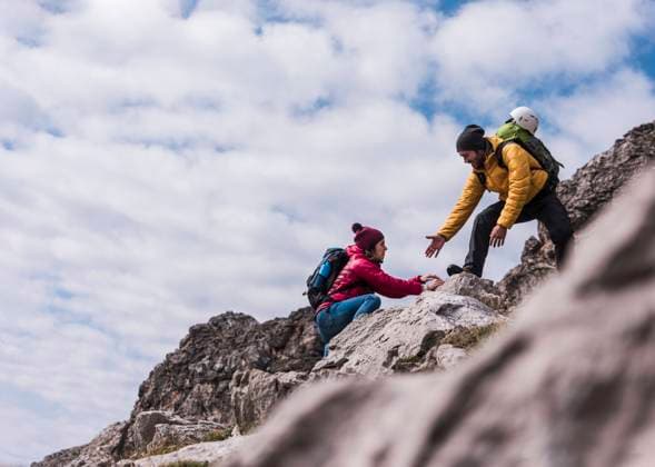 Man helping girlfriend in climbing up on mountain at Bavarian Alps, Germany model released, Symbolfoto, UUF31460