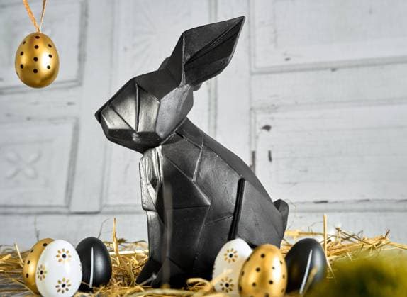 Augsburg, Bavaria, Germany - March 23, 2024: Abstract black Easter bunny figure with golden eggs in straw. Symbolic image Easter Luxury and Elegant *** Abstrakte schwarze Osterhasen Figur mit goldenen Eiern in Stroh. Symbolbild Ostern Luxus und Elegant