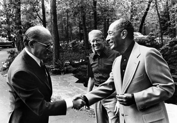 CAMP DAVID SUMMIT, 1978. Prime Minister Menachem Begin of Israel (left) shakes hands with President Anwar Sadat of Egypt during their summit meeting in Camp David, Maryland, hosted by U.S. President Jimmy Carter (center), 7 September 1978.  Copyright: xGRANGERx xGRANGERx 0115815