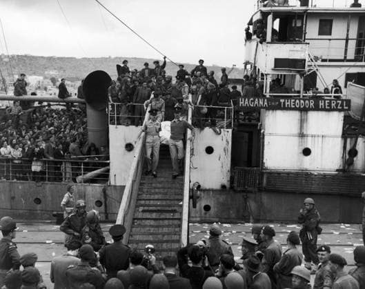 JEWISH REFUGEES. Police officers remove the body of a slain Jewish refugee, draped in a white Zionist flag, off the Hagana ship Theodore Herzl, off the coast of Haifa. Photograph, mid 20th century.  Copyright: xGRANGERx xGRANGERx 0122984