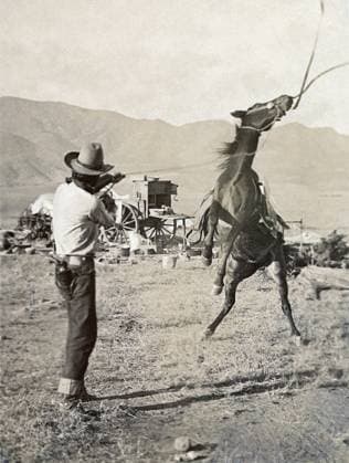 TEXAS: COWBOY, c1910. A cowboy holding a rope around the neck of a bucking bronco on a ranch in Texas. Photograph by Erwin Evans Smith, c1910.  Copyright: xGRANGERx xGRANGERx 0124949