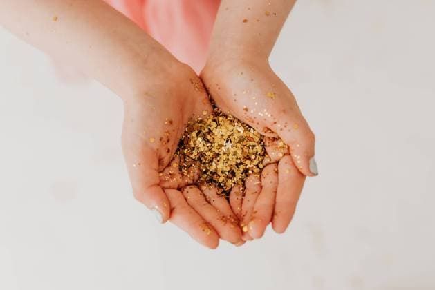 Creative Highlights Symbolbilder Overhead shot of young girl holding handful of gold glitter Sioux Falls, South Dakota, United States R_ASWE240321-1369521-01 ,model released, Symbolfoto