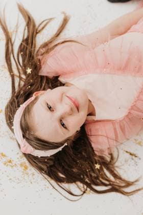 Creative Highlights Symbolbilder Young girl smiling lays on white backdrop covered with glitter Sioux Falls, South Dakota, United States R_ASWE240321-1369523-01 ,model released, Symbolfoto