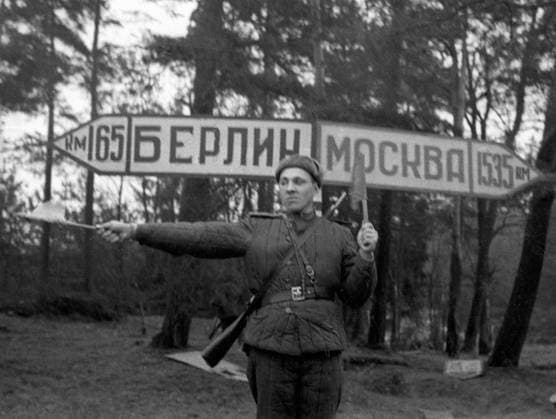 WWII TRAFFIC POLICEMAN SIGN 5410 16.04.1945 A traffic policeman with flags in his hands standing near Berlin-Moscow guide-sign. Ryumkin Sputnik Germany  Copyright: xRyumkinx