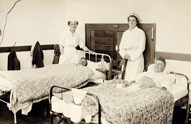 FLU PANDEMIC, 1918. Volunteer Red Cross nurses with patients in the barracks hospital at Colorado Agricultural College in Fort Collins, Colorado, during the influenza pandemic. Photograph, 1918.  Copyright: xGRANGERx xGRANGERx 0529243