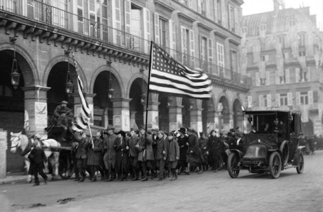 WWI: ARMISTICE, 1918. Crowd parading down Rue de Rivoli with an American flag in Paris, France, celebrating the armistice between the Allies and Germany; the city s American Red Cross headquarters is visible behind them. Photograph, 11 November 1918.  Copyright: xGRANGERx xGRANGERx 0642296