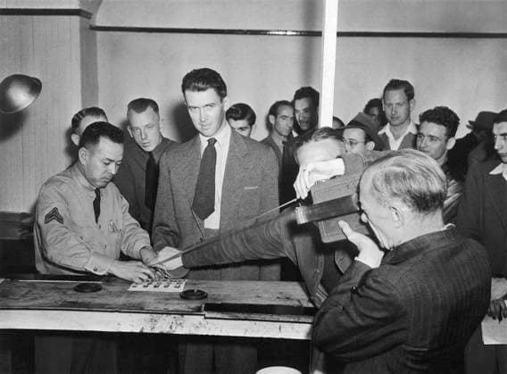 JAMES STEWART (1908-1997). American actor. Having his fingerprints taken as part of his induction into the United States Army Air Corps, Los Angeles, California. Photograph, 22 March 1941.  Copyright: xGRANGERx xGRANGERx 0644806