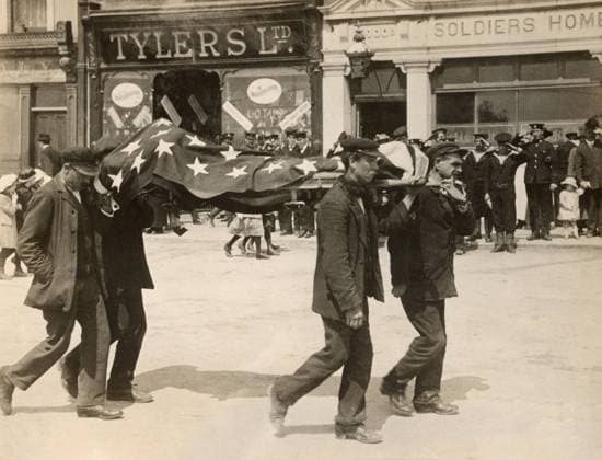 WWI: LUSITANIA, 1915. A flag-draped body of an American victim from the sinking of RMS Lusitania being carried to a temporary morgue in Cobh, Ireland. Photograph, May 1915.  Copyright: xGRANGERx xGRANGERx 0645794