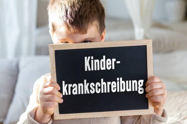 29 March 2024: Little boy holding a board with the inscription: Kinderkrankschreibung. PHOTOMONTAGE *** Kleiner Junge hält eine Tafel mit Aufschrift: Kinderkrankschreibung. FOTOMONTAGE