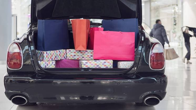 An advertising car stands in a shopping center. The open trunk of a car is full of shopping bags. An advertising car stands in a shopping center. The open trunk of car is full of shopping bags. Copyright: xZoonar.com EvgeniixLashchenovx 18668957