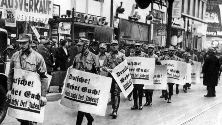 Germany: Nazi stormtroopers march with signs reading Germans Defend Yourselves - Don t Buy from Jews , 1938 Kristallnacht or Crystal Night , also referred to as the Night of Broken Glass, was a pogrom against Jews throughout Nazi Germany and Austria that took place on 9 10 November 1938, carried out by SA paramilitary forces and German civilians.<br ><br > German authorities looked on without intervening. The name Kristallnacht comes from the shards of broken glass that littered the streets after Jewish-owned stores, buildings, and synagogues had their windows smashed. Copyright: xxPicturesxFromxHistoryx