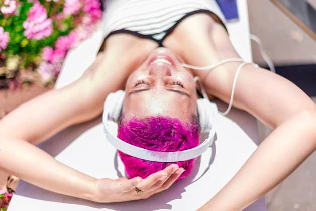 Creative Highlights Symbolbilder Woman with purple hair and headpones is listening music in her mobile Santa Cruz de Tenerife, Canary Islands, Spain R_NINA211220-887875-01 ,model released, Symbolfoto