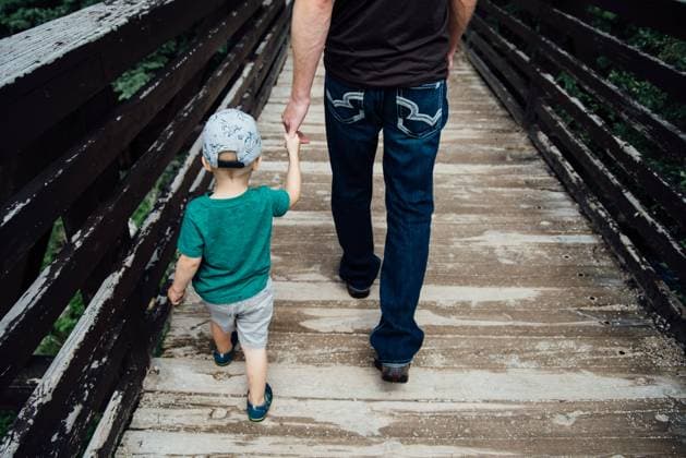 Overhead rear view of dad leading son across bridge in summer. Keystone, South Dakota, United States CR_KIFR240402-1377297-01 ,model released, Symbolfoto
