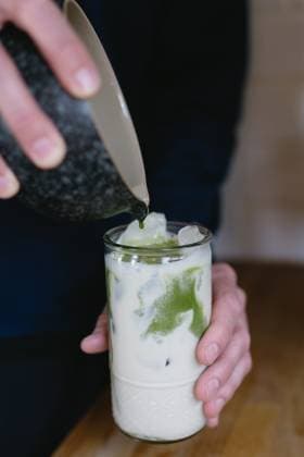 pouring green tea into milk for matcha latte Bloomington, Indiana, United States R_QGNV240402-1384560-01 ,model released, Symbolfoto