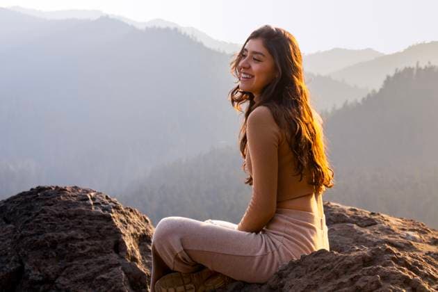 Creative Highlights Symbolbilder A joyful woman sits basking in the golden light of sunrise on a mountain peak, with a stunning backdrop of misty mountains Model Released EduardoGavira_ID20255_599089_020 Copyright: xEduardoxGavirax RECORD DATE NOT STATED