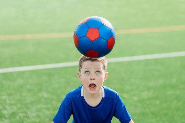 Creative Highlights Symbolbilder A young boy in a blue jersey balances a red and blue soccer ball on his head with a look of concentration Model Released HodeiUnzueta_ID20078_594457_066 Copyright: xHodeixUnzuetax