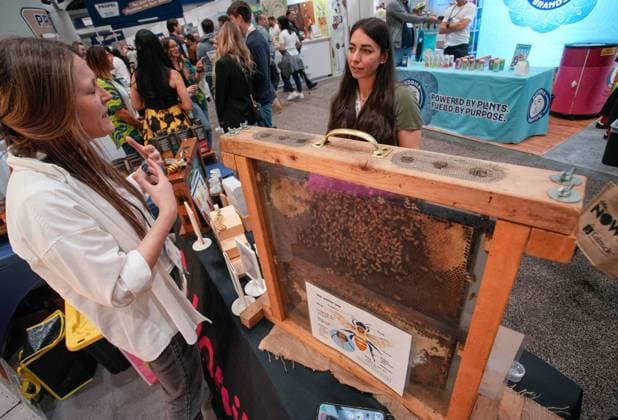 (240405) -- VANCOUVER, April 5, 2024 -- An attendee talks with an exhibitor at a stand selling natural honey products during the 2024 CHFA NOW trade show in Vancouver, British Columbia, Canada, on April 5, 2024. Over 900 exhibitors from across the world showcased their latest natural, organic and wellness products at the CHFA NOW, a health food trade show hosted by Canadian Health Food Association (CHFA). (Photo by Xinhua) CANADA-VANCOUVER-CHFA NOW-TRADE SHOW LiangxSen 