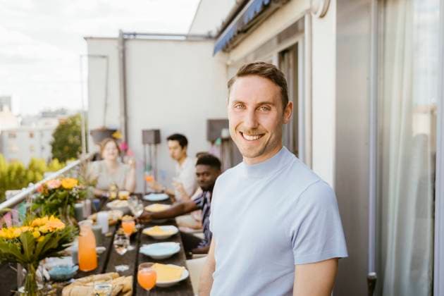 Portrait of smiling man with multiracial friends celebrating during dinner party in balcony Germany, Berlin, model released, property released Copyright: xMaskotx , MA108115 MA108115