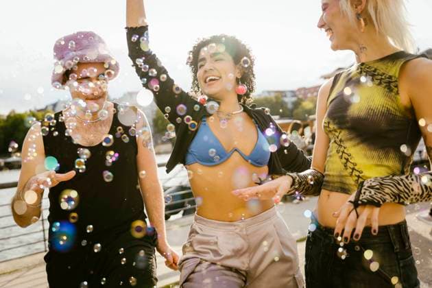 Carefree non-binary friends playing with bubbles on promenade in city Germany, Berlin, model released Copyright: xMaskotx , MA108311 MA108311