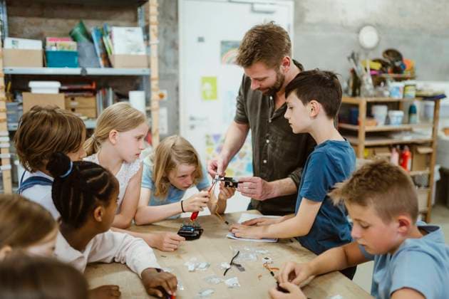 Male teacher helping students while working on robotics project at workshop in school Germany, Berlin, model released, property released Copyright: xMaskotx , MA108535 MA108535