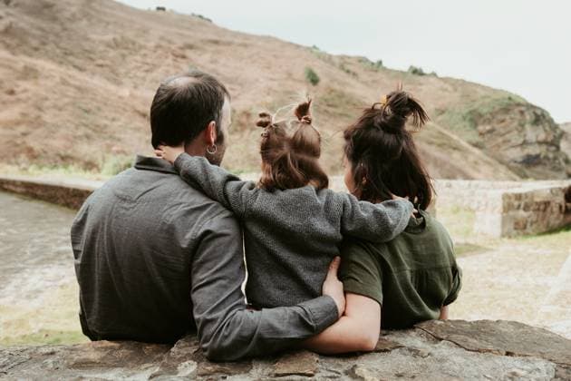 Creative Highlights Symbolbilder A heartwarming moment of a family sitting closely together outdoors, overlooking a hilly landscape, sharing a bond of love and companionship Model Released HodeiUnzueta_ID20569_607675_002 Copyright: xHodeixUnzuetax