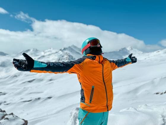 An exuberant skier in colorful gear stretches arms wide, embracing the panoramic view of a pristine snow-covered mountain vista Model Released IrinaChetverikova_ID20954_618027_002 Copyright: xIrinaxChetverikovax RECORD DATE NOT STATED