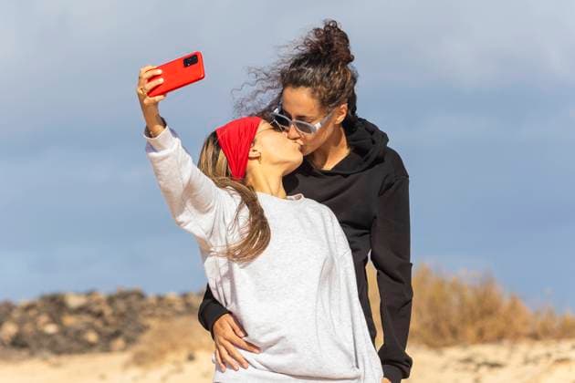 A happy couple captures a tender moment with a selfie kiss during their beach camping trip under a cloudy sky Model Released JuanAizpuru_ID20478_604875_004 Copyright: xJuanxAizpurux
