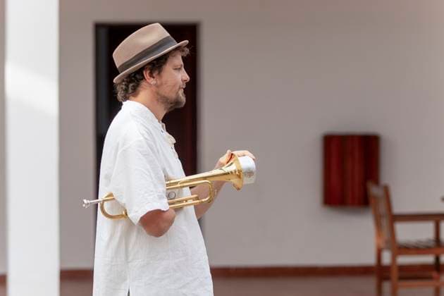 Creative Highlights Symbolbilder A dedicated trumpeter with one arm is immersed in his practice session, showcasing determination and passion for music in a home setting Model Released JuanAizpuru_ID20819_614043_020 Copyright: xJuanxAizpurux