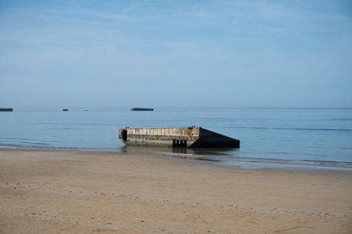 Detail of a fragment of the Mulberry artificial port from Operation Overlord D-Day. It is half buried and stuck on the beach, it is full of moss 23533176 RECORD DATE NOT STATED