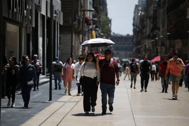 Mexiko, Rekordtemperaturen in Teilen des Landes (240417) -- MEXICO CITY, April 17, 2024 -- Two pedestrians shield themselves from the sun with an umbrella in Mexico City, Mexico, on April 16, 2024. (Photo by Xinhua) MEXICO-MEXICO CITY-HEAT WAVE FranciscoxCanedo 