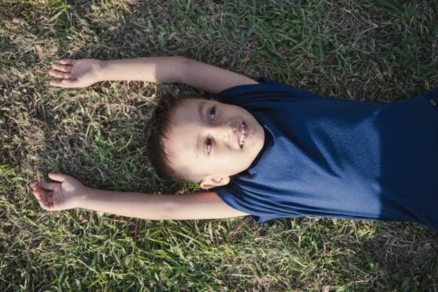Creative Highlights Symbolbilder Little cute boy is lying on the green grass on a sunny day Chiclayo, Lambayeque, Peru R_BILL240416-1402664-01 ,model released, Symbolfoto