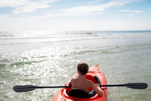 Child kayaking in calm ocean waters on sunny day Cape San Blas, Florida, United States CR_RCYA240421-1401490-01 ,model released, Symbolfoto