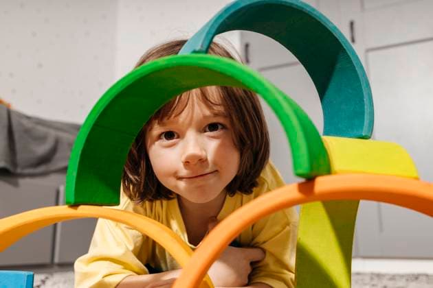Creative Highlights Symbolbilder Smiling boy playing with rainbow shaped pyramid toy at home model released, Symbolfoto property released, ELMF00133