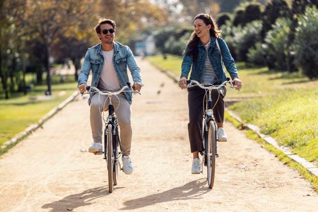 Happy couple cycling and having fun on footpath at park model released, Symbolfoto, JSRF02985