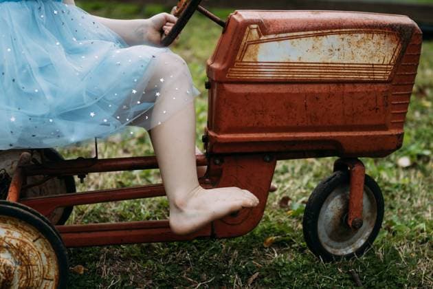 IMAGO Creative: Sommer, Sommertage im Garten Child riding vintage pedal tractor toy in yard McClure, Illinois, United States R_WEKW240423-1409192-01 ,model released, Symbolfoto