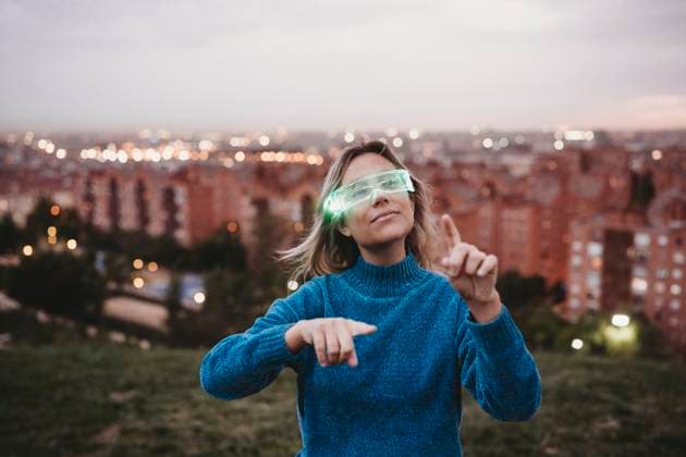 Creative Highlights Symbolbilder Woman wearing smart glasses and pointing with city in background model released, Symbolfoto, EBBF08924