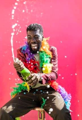 Creative Highlights Symbolbilder Happy non-binary person enjoying champagne celebration against pink background model released, Symbolfoto property released, JCCMF11672