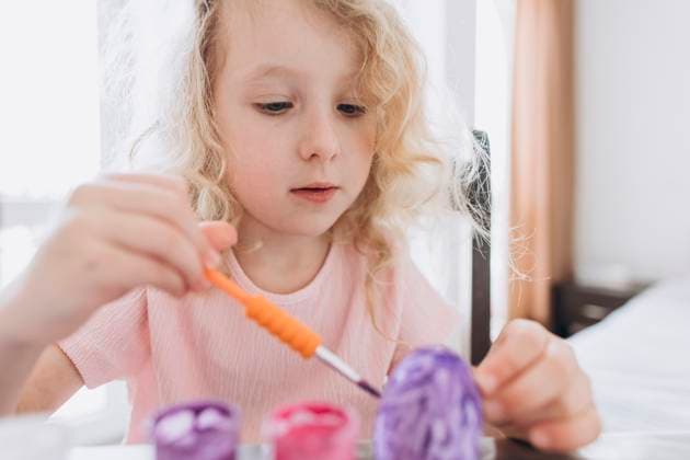 Creative Highlights Symbolbilder Blond girl coloring and decorating eggs for Easter at home model released, Symbolfoto, SIF01081