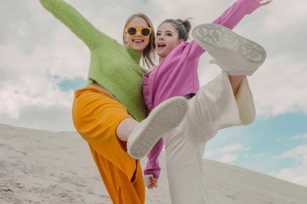 Creative Highlights Symbolbilder Cheerful women enjoying together on sand dune model released, Symbolfoto, VSNF01876