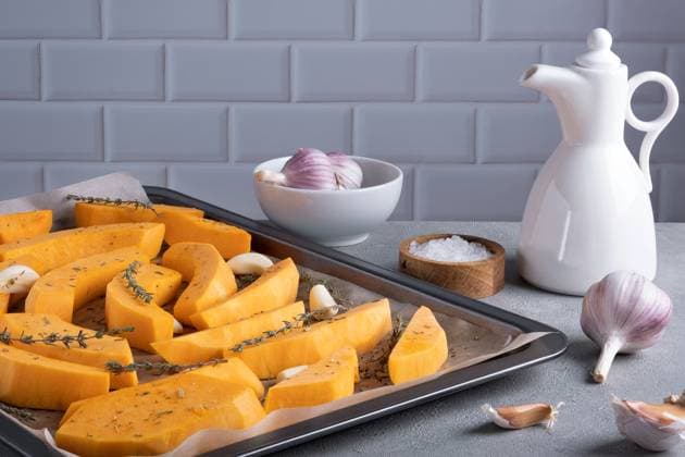 IMAGO Creative, Herbst, Food, Ofenkürbis Pieces of ripe pumpkin prepared for baking Pieces of ripe pumpkin prepared for baking on a baking sheet with olive oil, garlic and dry thyme on the kitchen table. Healthy food. Selective focus. Copyright: x RECORD DATE NOT STATED