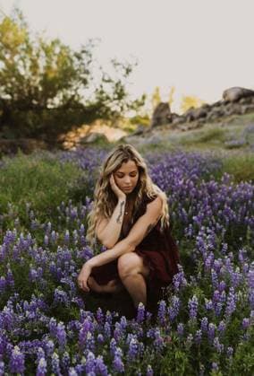 Creative Highlights Symbolbilder Serenity in bloom: tattooed woman amidst purple lupines at dusk Roseville, California, United States CR_ZXOF240426-1413642-01 ,model released, Symbolfoto