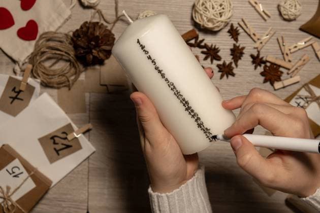 Unrecognizable young woman paint numbers on candles. Female making homemade advent calendar Made with your own hands step by step DIY crafts do it yourself. Preparation to christmas concept. Seasonal activities for children family winter holidays Unrecognizable young woman paint numbers on candles. Female making homemade advent calendar Made with your own hands step by step DIY crafts do it yourself. Preparation to christmas concept. Seasonal activities for children family winter holidays. Eco friendly presents gifts. open the package every day Copyright: x RECORD DATE NOT STATED