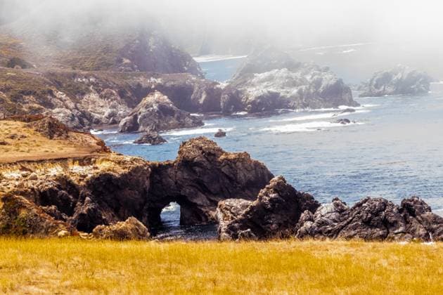 Creative Highlights World Rocky coastline with sea arches in a misty Big Sur landscape Big Sur, California, United States R_OCZQ2405077F-1420155-01